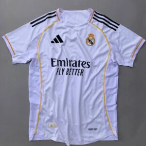 Real Madrid 2025/26 home jersey with classic white design, black adidas stripes, golden-yellow trim, Emirates Fly Better sponsor, and embroidered club crest – official fan and player kit